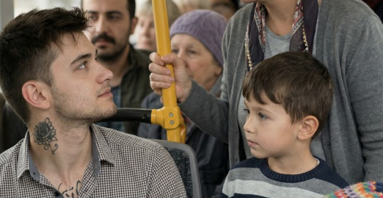 Otobüste yanında iki çocuğu olan bir kadın ayakta bekliyordu